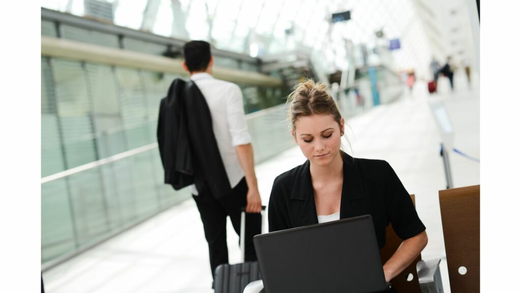 Professional woman sitting at the airport and using the public WiFi while waiting for her flight