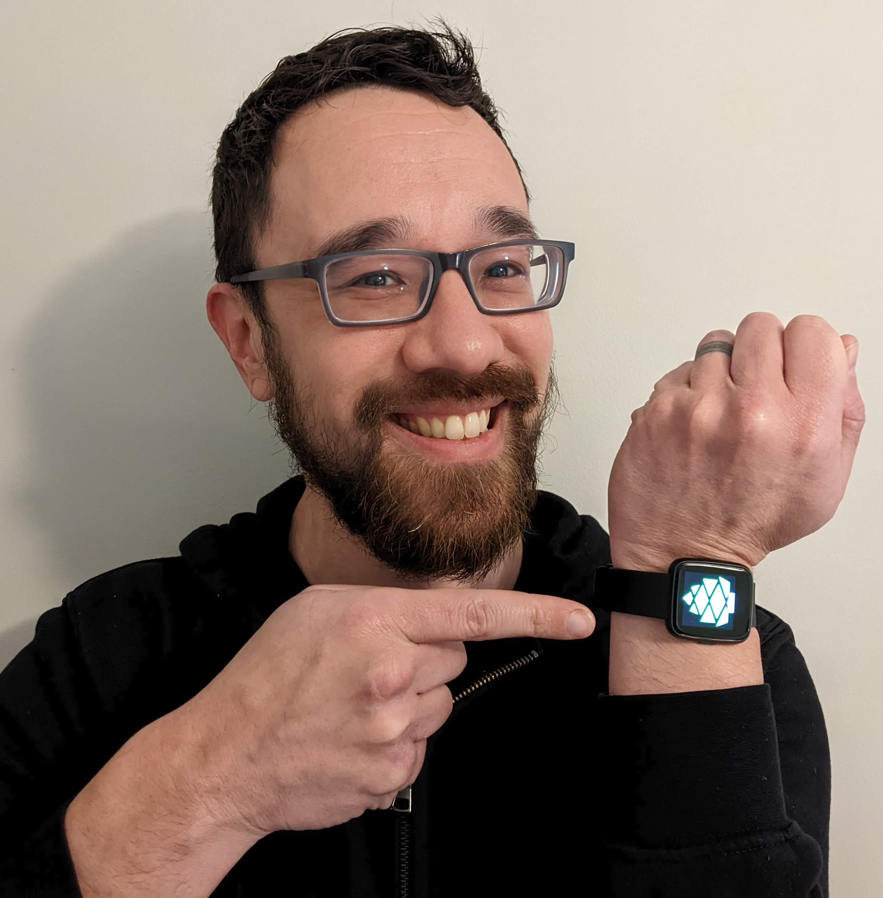 Mike Chu pointing at his PineTime, the best minimalist smartwatch for privacy
