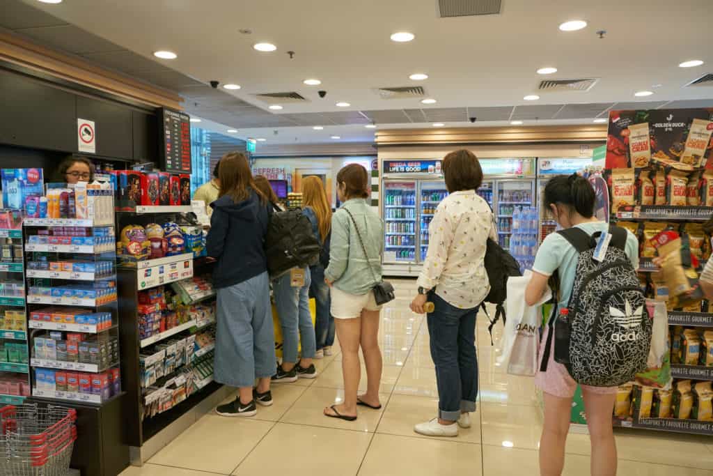 People in a convenience store line one of which is buying a burner phone number which can't be traced