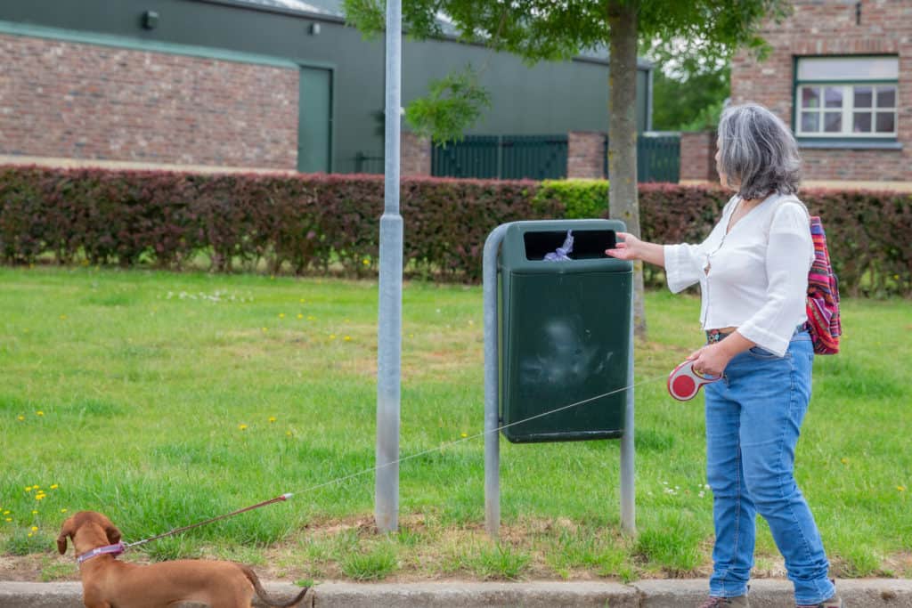 Older woman in a park throwing away her burner phone number so she can't be traced