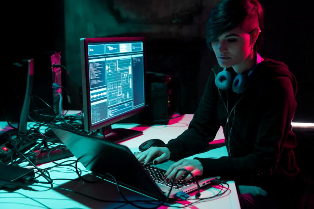 Hacker working on her laptop, sorting all types of encrypted data