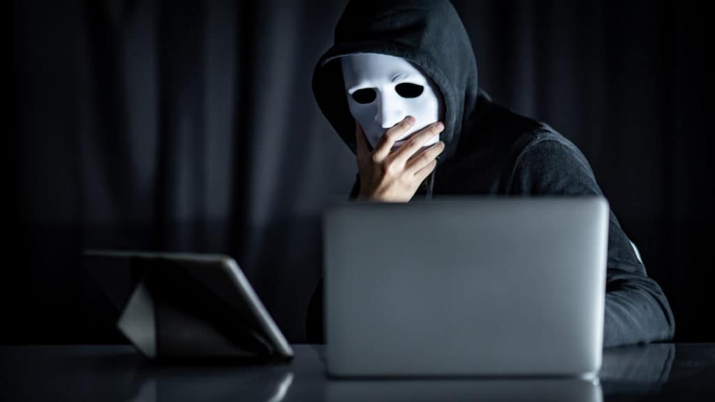 Masked hacker thinking about why you should encrypt data