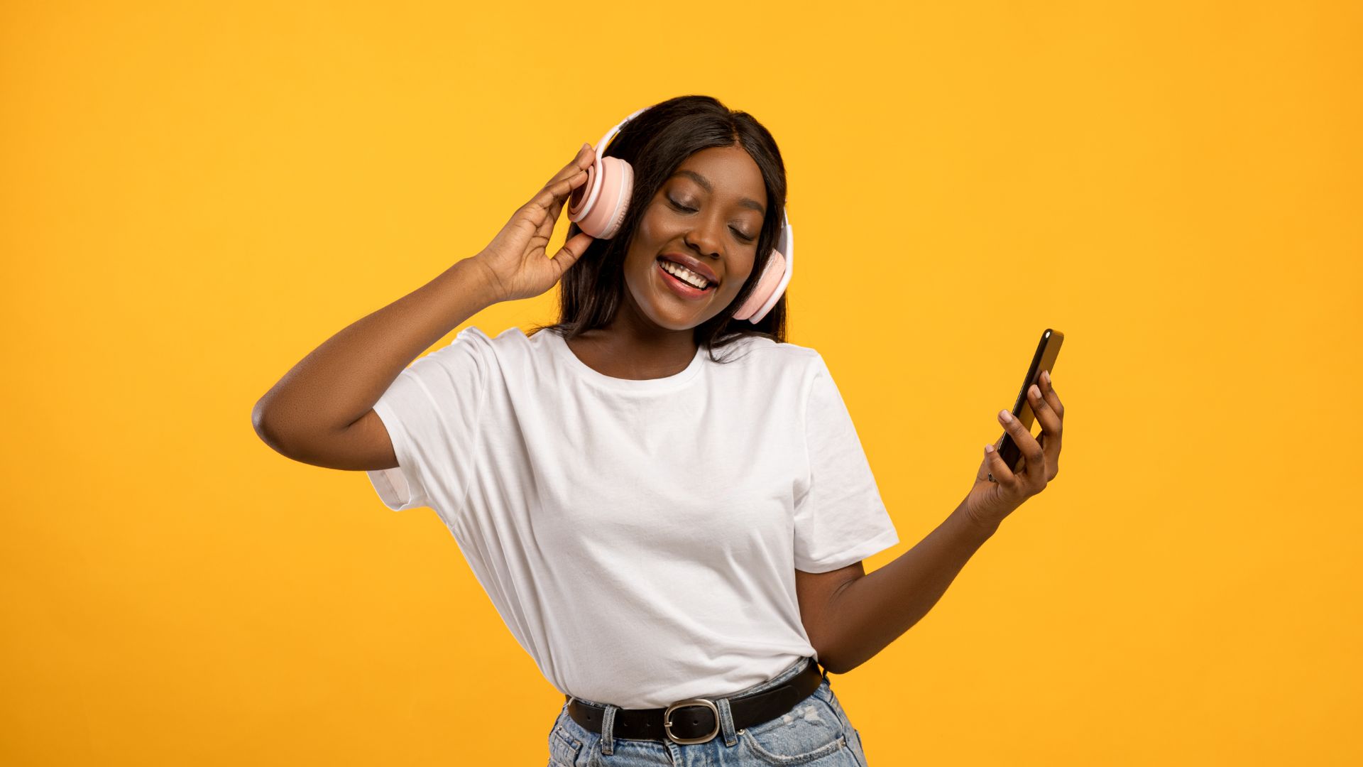 A woman listening to music from her phone using a connected Bluetooth-enabled headset.