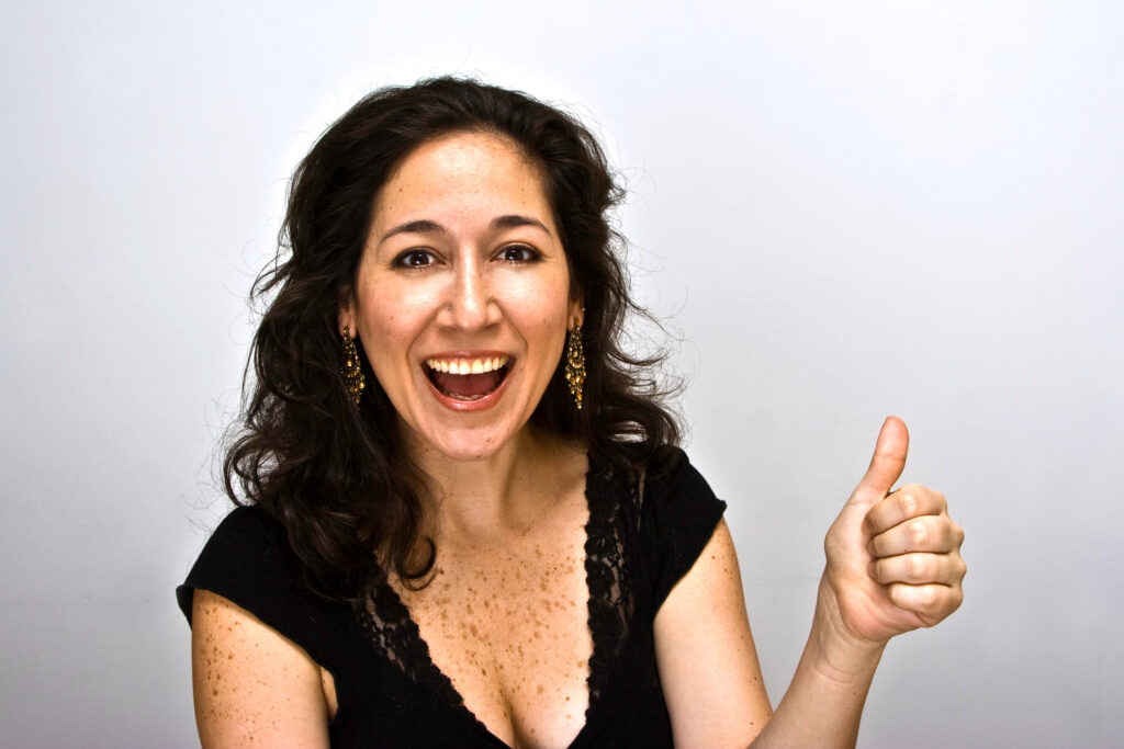Smiling woman with her thumb up knowing tips to protect an email address.