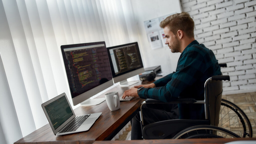 Man at desk with computers performing email header analysis