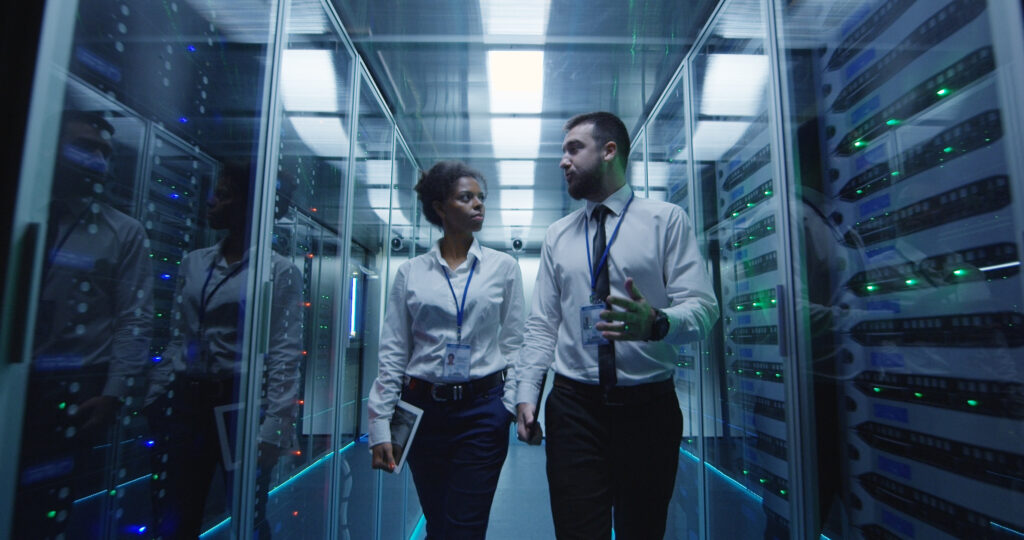 Law enforcement IT workers in server room talking about email forensics