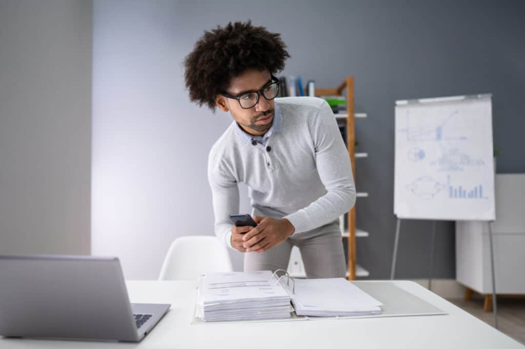 Man taking smartphone picture watching out and wondering how to hide numbers on your phone bill