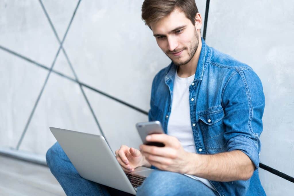 Man using Brave browser's safe sync chain on laptop and smartphone