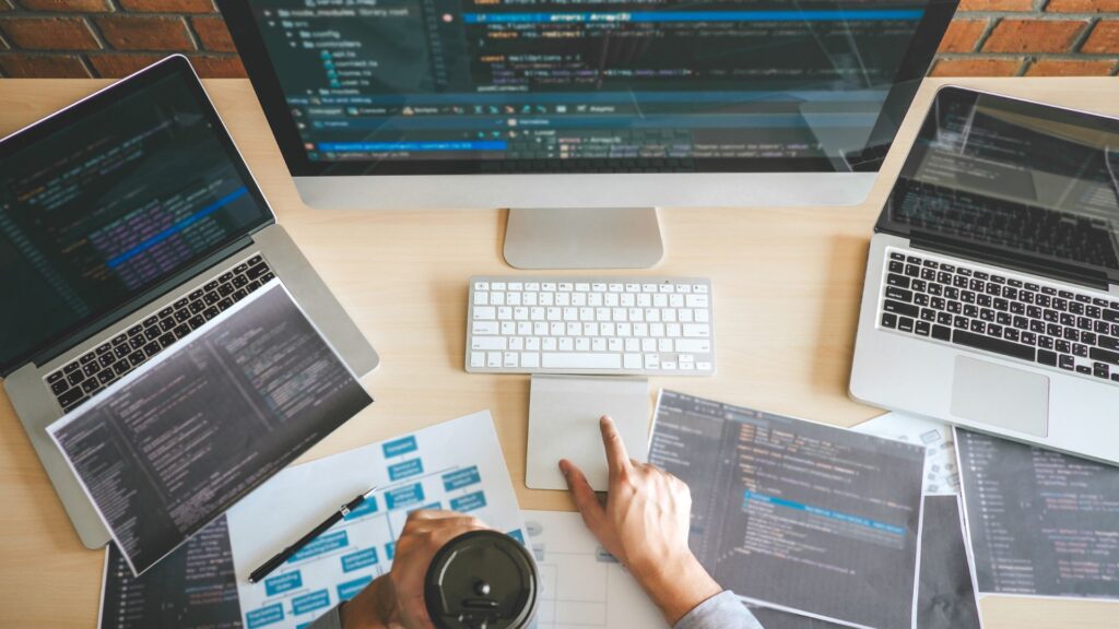 A table filled papers, mind-maps, and code while doing research for software project