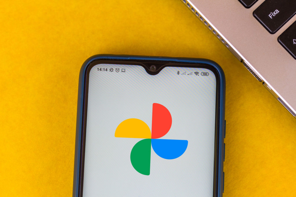 A cell phone showing the Google Photos logo.