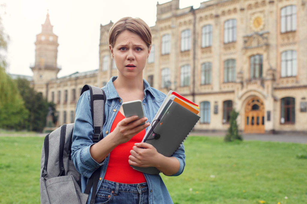 Student at university holding smartphone concerned: is MMS safe any more