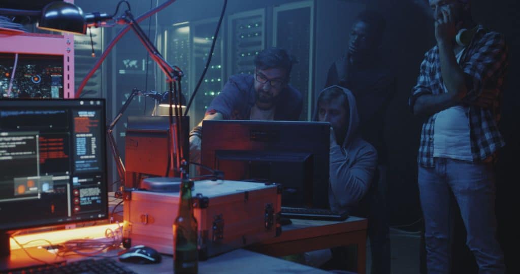 4 hackers in basement lair committing cybercrime stressing the importance of online privacy