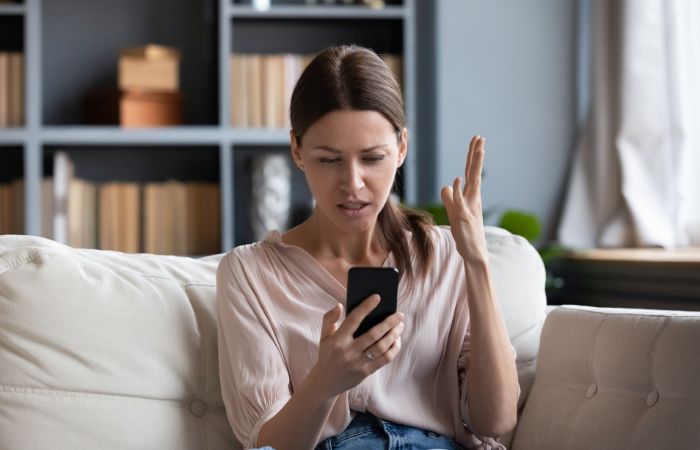 Angry woman having problems with phone. Her phone has a very slow performance because of spyware.